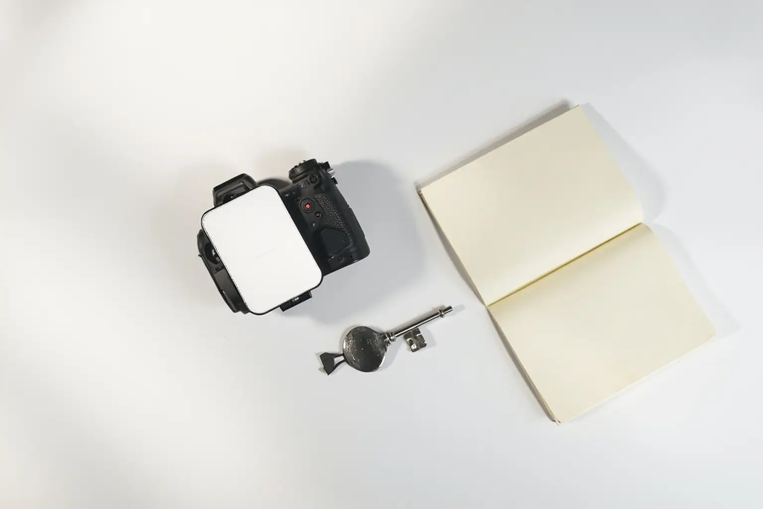 Câmera e chave de estúdio representando planejamento de consórcio de equipamento fotográfico